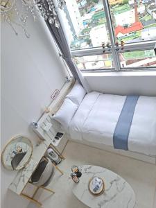 Zimmer mit einem Bett und einem großen Fenster in der Unterkunft Angel House in Daegu