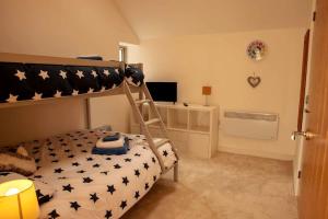 ein Schlafzimmer mit einem Etagenbett und einem Schreibtisch in der Unterkunft The Coach House - Raskelf - YO61 3LD 