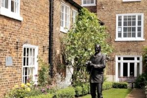 una estatua de un hombre parado frente a un edificio en The Coach House - Raskelf - YO61 3LD, 