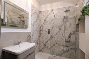 uma casa de banho com um chuveiro em mármore e um lavatório. em The Coach House - Raskelf - YO61 3LD 