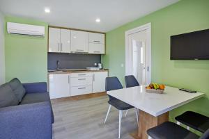 een keuken en een woonkamer met een tafel en stoelen bij Mobile Homes Terme Jezercica in Donja Stubica
