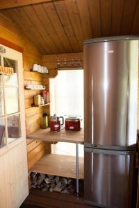 a kitchen with a stainless steel refrigerator in a cabin at Avar puhkekompleks saunaga in Kuusiku