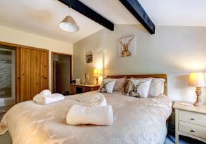 a bedroom with a large bed with towels on it at Foss Garth Cottage in Thwaite