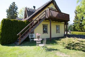 a small house with a roof with a table and chairs at Avar puhkekompleks saunaga in Kuusiku