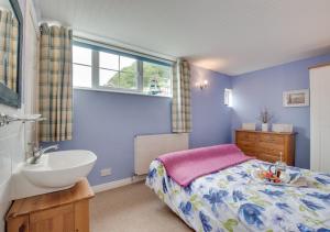 a blue bedroom with a bed and a sink at Flat 4 Whitehaven in Sandsend