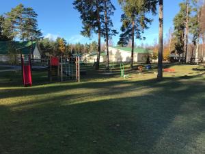 un parque con un parque infantil con árboles y un edificio en Puhkekeskus SUVI, en Karjamaa
