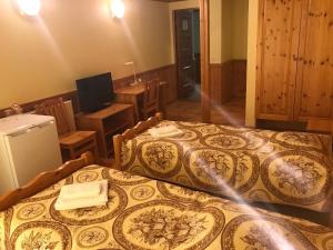Duas camas num quarto com uma cozinha e uma televisão em Puhkekeskus SUVI em Karjamaa