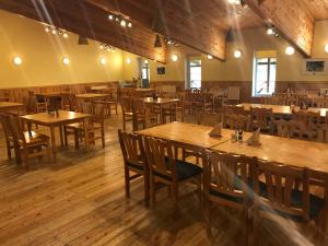 an empty restaurant with wooden tables and chairs at Puhkekeskus SUVI in Karjamaa