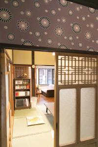 a living room with a patterned wall at Female-Only Guesthouse Tomari-ya in Tondabayashi