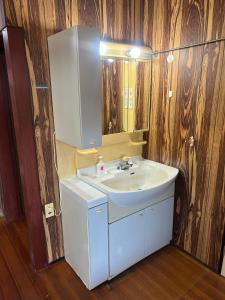 ein Badezimmer mit einem weißen Waschbecken und einem Spiegel in der Unterkunft Stella in Noto in Togi