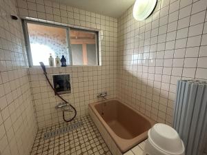 uma casa de banho com uma banheira, um WC e uma janela. em Stella in Noto em Togi