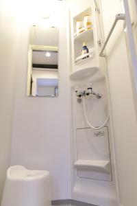 Baño blanco con aseo y lavamanos en Female-Only Guesthouse Tomari-ya en Tondabayashi