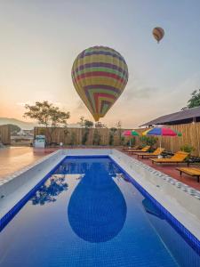 a hot air balloon flying over a swimming pool at Vang Vieng Chill House in Vang Vieng