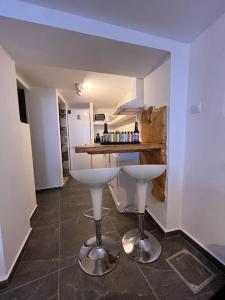 - une cuisine avec deux tabourets de bar blancs dans une pièce dans l'établissement Aquamarine, à Firopótamos