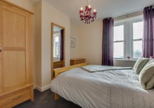 a bedroom with a bed and a window and a chandelier at Fellside in Kettlewell