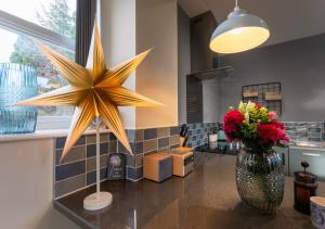 a large star decoration on a counter with a vase of flowers at Fellside in Kettlewell
