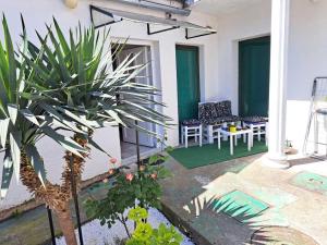 a patio with a table and chairs and a plant at Stefan Apartman in Novi Sad