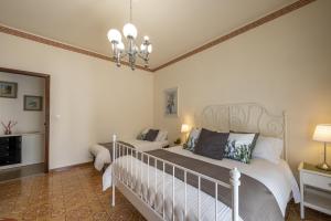 um quarto com uma cama e um lustre em Etna Sicilian House em Linguaglossa