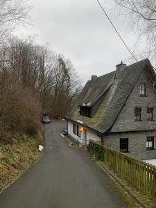 una casa vieja al lado de una carretera en Berghaus 2 komfortable Wohnungen für bis zu 7 Personen - Familie - Wandern - E-Bike - Hunde - E-Ladesäule - WiFi, en Schmallenberg