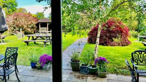 een uitzicht op een tuin met een tafel, stoelen en bloemen bij Notley Arms Inn Exmoor National Park in Elworthy