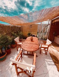 un tavolo e sedie in legno su un patio di LA MAISON - Sea Appartment & Petit Chalet en Bois for 4 SEASONS a Golem