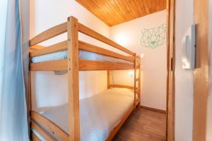 a bunk bed in a room with two bunk beds at Le Petit Lieu Les Orres Appartement Charmant in Les Orres