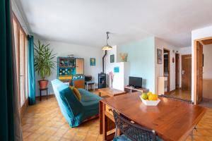 sala de estar con mesa y sofá azul en Le Petit Lieu Les Orres Appartement Charmant, en Les Orres