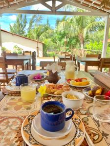 a table with breakfast foods and drinks on it at Pousada da Renata in Jericoacoara