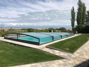 a swimming pool in the middle of a grass field at Olive Apartman in Alsóörs