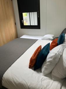 a bedroom with two beds with orange and blue pillows at Woudmeer 1 in Dirkshorn