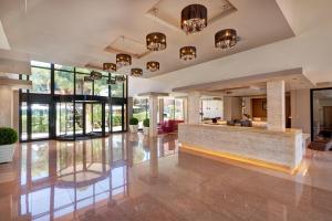 a lobby with a reception counter and windows at Protur Turo Pins 4* SUP in Cala Ratjada