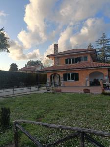 ein Haus mit einem Zaun vor einem Hof in der Unterkunft Serendipity in Grottaferrata