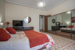 a bedroom with a large bed and a flat screen tv at Etna Sicilian House in Linguaglossa