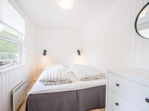 a white bedroom with a bed and a window at Holiday home Nørre Nebel LXXXIV in Nørre Nebel