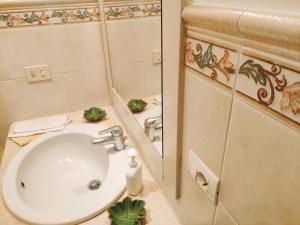 a bathroom with a white sink and a mirror at Dimora del Sole in Martina Franca