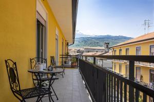 a balcony with a table and chairs on a building at Etna Sicilian House in Linguaglossa