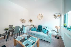 a living room with a couch and a table at Cozy 1-Bedroom Apartment in the Heart of Barnsley Town Centre in Barnsley