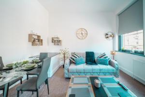 a living room with a blue couch and a table at Cozy 1-Bedroom Apartment in the Heart of Barnsley Town Centre in Barnsley