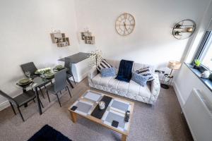 a living room with a couch and a table at Cozy 1-Bedroom Apartment in the Heart of Barnsley Town Centre in Barnsley