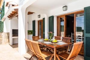 uma sala de jantar com uma mesa de madeira e cadeiras em Villa Vista Alegre - Cala Galdana em Ferreries