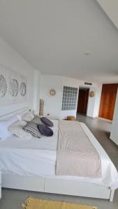 a white bed with pillows on it in a room at Moraira Beach in Moraira
