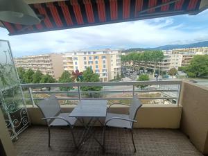 a balcony with a table and chairs and a view of a city at Provencal in Cagnes-sur-Mer