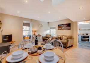 a kitchen and living room with a table and chairs at Eta Cottage in Kettlewell