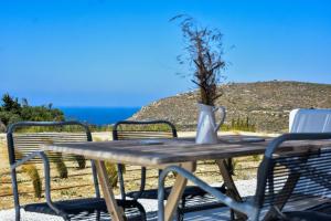 Relaxia Estate Naxos في Galini: طاولة خشبية مع كراسي و مزهرية عليها نبات