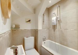 a bathroom with a toilet and a bath tub at Eta Cottage in Kettlewell
