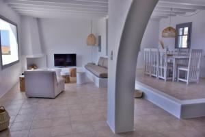 a living room with a couch and a dining room at Relaxia Estate Naxos in Galini