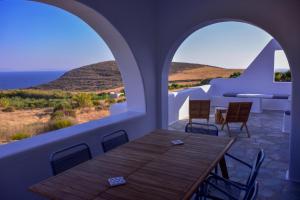 a table and chairs on a balcony with a view of the ocean at Relaxia Estate Naxos in Galini