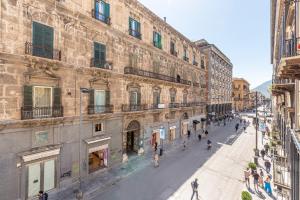 um grupo de pessoas andando por uma rua ao lado de um edifício em Appartamento Principe di Belmonte by Wonderful Italy em Palermo