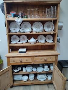 a cabinet filled with plates and cups and dishes at The Old House at Belfield in Tralee