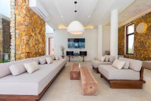 a living room with couches and a stone wall at Hoàng My Villa S7 in Vung Tau